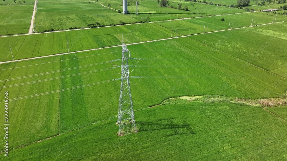 Fototapeta premium high voltage transmission tower in green farmland of xinjiang