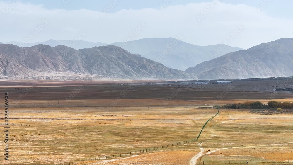 Fototapeta premium vast grassland and distant mountains landscape in xinjiang