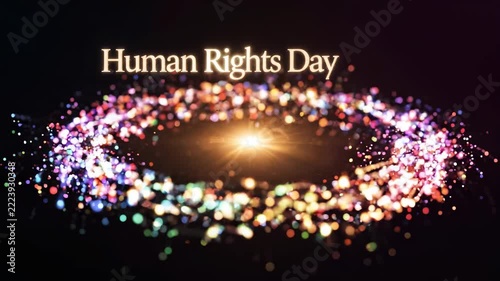 Human Rights Day text above a vibrant, sparkling, colorful light vortex on a dark background, resembling a cosmic event or galaxy.