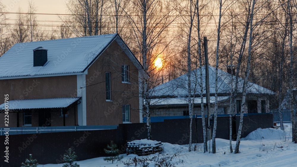 Fototapeta premium Snow-covered houses stand in a quiet winter scene