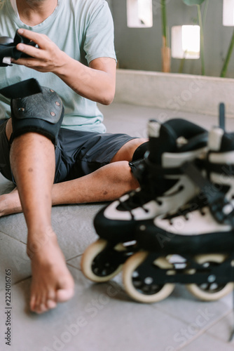 Person preparing protective gear before inline skating outdoors
