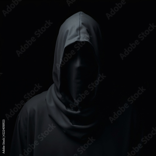 faceless figure in dark hood representing grim reaper or ghost