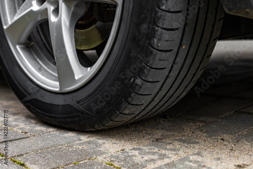 Close-up of car tire and alloy wheel on pavement