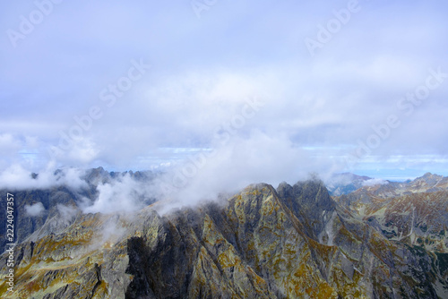 View of mountain peaks hidden in clouds. The High Tatras seen from Rysy. Tatra Mountains.	
