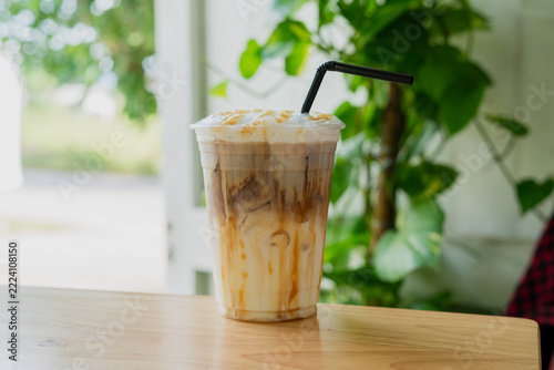 barista prepares a delicious iced caramel macchiato with espresso, fresh milk ice and caramel sauce creating refreshing coffee shop beverage for the menu.