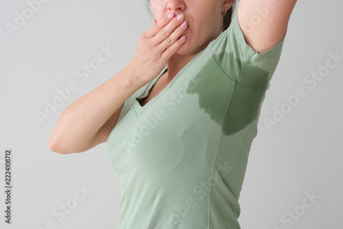 The woman has a wet sweat stain on her T‑shirt.