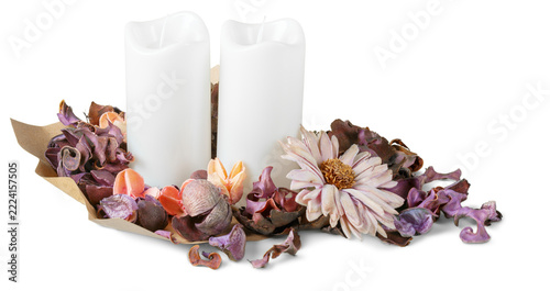Decorative arrangement with white candles and dried flower petals on a simple background