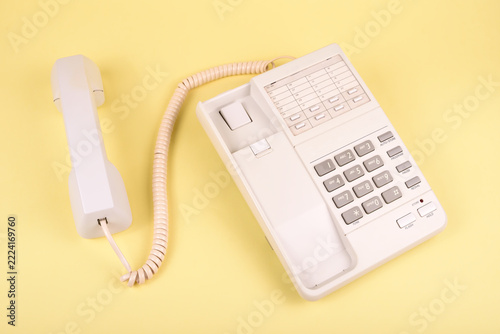 Retro white telephone on a yellow background. Top view. Concept of vintage technology, traditional telecommunication and minimalism.