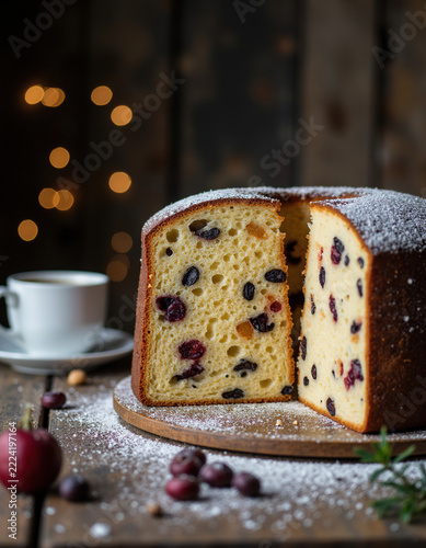 Traditional Italian Christmas panettone cake with raisins and dried cranberries sprinkled with powdered sugar