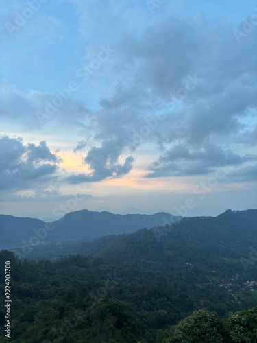 sunset view from the top of the hill with clouds over the mountains
