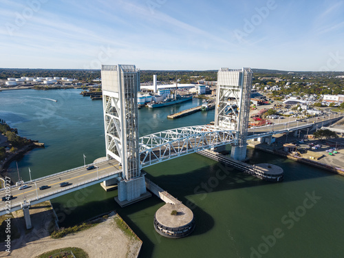 Aerial view of the Fore River Bridge spanning the Fore River with industrial facilities and ships in the background in Quincy, Massachusetts, United States.