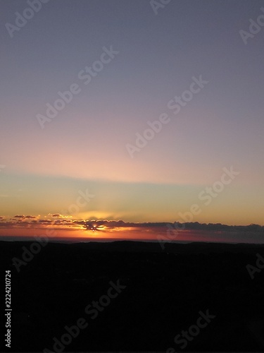 Beautiful golden sunset sky background with sun rays and dark silhouette copy space