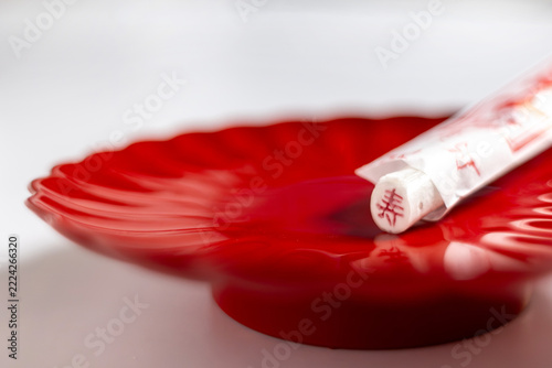 Close up of a Japanese Chitose Ame candy with a kanji character on a red plate