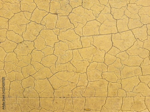 Cracked Yellow Wall Paint Texture Closeup Abstract Background of Peeling Weathered Surface
