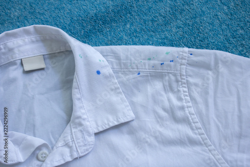 Close-up of a white shirt collar and blue ink stains on the fabric. Ink contamination and clothing stain removal concept.