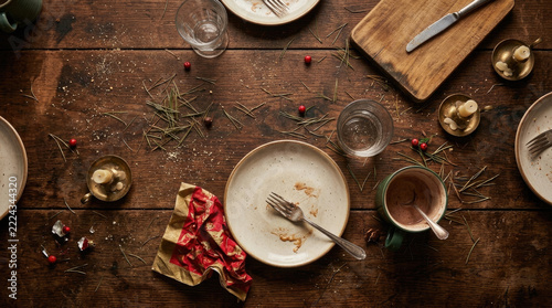 Festive table setting with empty plates, cutlery, and remnants of meal, evoking cozy atmosphere