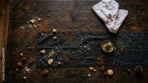 Messy table with spices, herbs, and cookies scattered around, creating cozy atmosphere