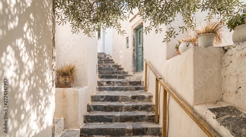 Narrow stone staircase in a traditional greek village with white