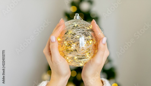 Female hands holding a Christmas glass ball Bauble ornament 