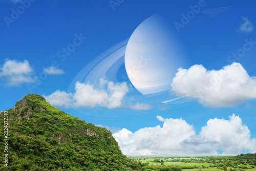 Saturn near earth back on the blue sky and white cloud over mountain