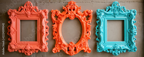 Baroque style ornate picture frame set in coral and turquoise colors with intricate floral and scrollwork details on textured wall