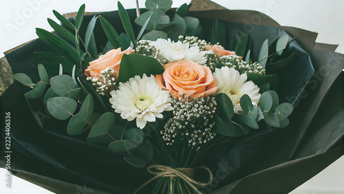 Elegant floral bouquet with peach roses and white daisies wrapped in