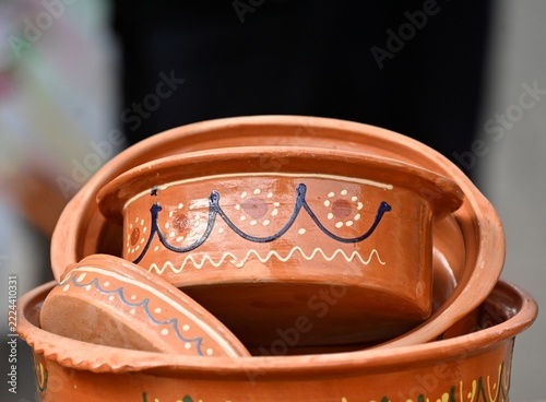 Stacked terracotta clay bowls from macedonia featuring hand-painted traditional decorative patterns.