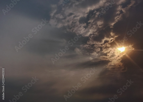Dramatic Sunlight Breaking Through Dark Gray Clouds in an Overcast Sky
