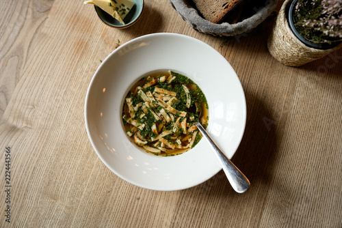 Pancake strip soup in clear broth with chives in a cozy Bavarian restaurant