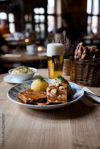 Bavarian roast pork with crispy crackling, dumplings and gravy served with beer