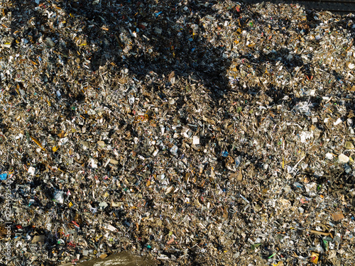 Aerial view of a large pile of mixed scrap metal and recyclable waste at a recycling facility in the United Kingdom.