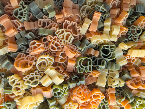 Top view of colorful uncooked animal shaped pasta texture background