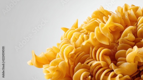 Close-Up View of Swirling Yellow Pasta Shapes on Neutral Background