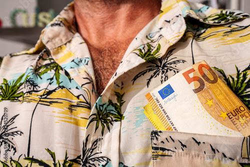 50 euro banknotes tucked in tropical print shirt pocket