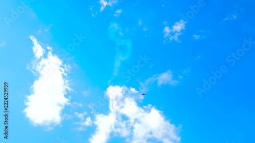 A red sports plane performing aerobatics with a smoke trail.