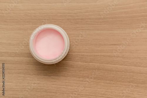 Pink powder in a white container for manicures. Space for text.