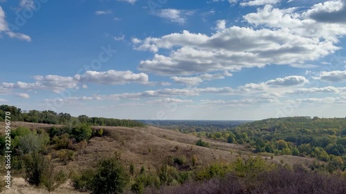 Scenic view of green hills and forest under a cloudy sky