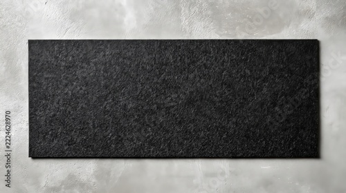 Blank black rectangular felt desk mat pad mockup on a light gray concrete textured background top view.