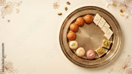 Minimalist arrangement of traditional Indian sweets on a golden tray with floral border