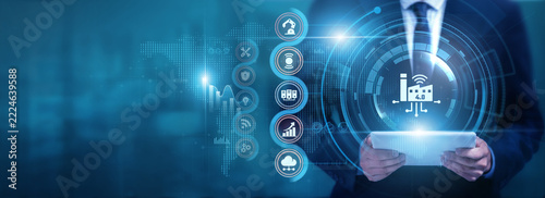 Businessman using tablet analyzing Industry 4.0 and manufacturing data, monitoring smart systems, optimizing automation, improving production efficiency and supporting digital transformation