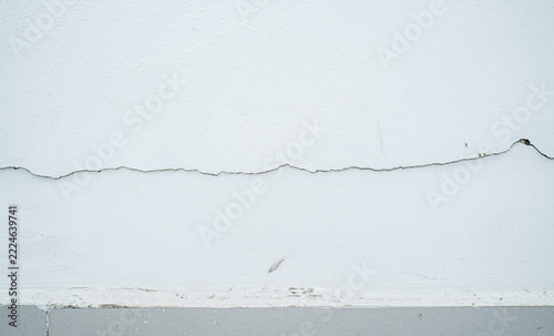 Pared blanca envejecida con grieta horizontal y pintura desgastada, textura de concreto minimalista