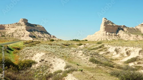Road view of asphalt highway winding toward towering sandstone bluffs at Scotts Bluff National Monument in Gering, Scotts Bluff County, Nebraska