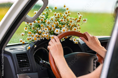 woman driving car, flowers on a dashboard