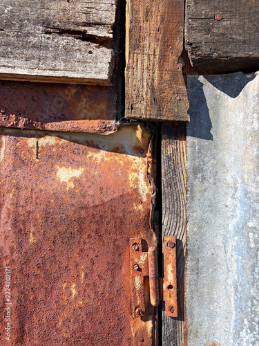 puerta con herraje bisagra con láminas de hierro metal oxidado chapas y madera fijadas entre sí con clavos IMG_9620-as26
