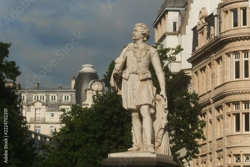 A refined Antwerp statue of Anthony Van Dyck, carved in pale marble, showing the painter in ornate historic attire with flowing hair,