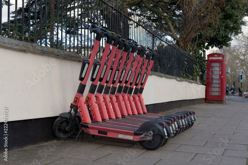 Electric scooters parked in a row on a busy street