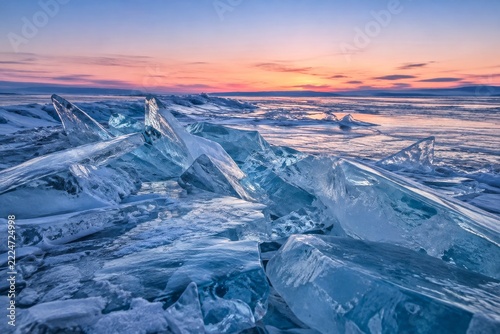Jagged blue lake ice stretching toward a pink winter twilight horizon