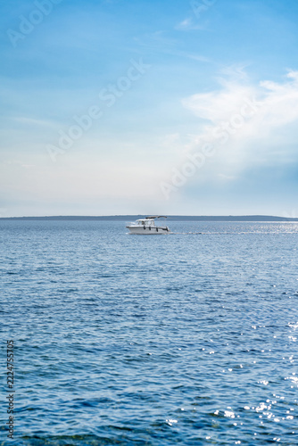 Motorboat cruising tranquil blue ocean on sunny summer day