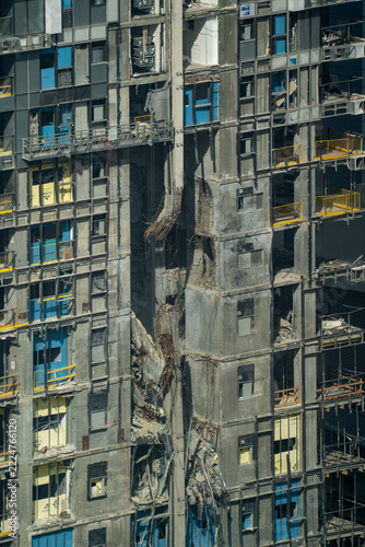 Damaged high-rise facade undergoing extensive exterior reconstruction