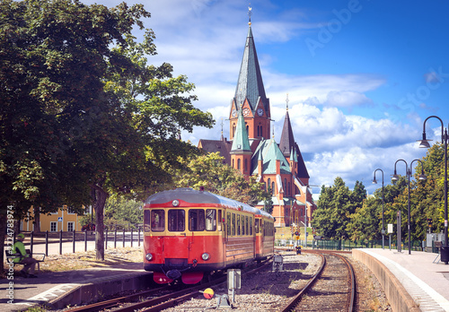 Historic Red Railbus at Västervik Railway Station with St Gertrude Church in Sweden